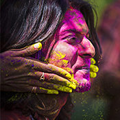 Person having their face covered in colourful powder