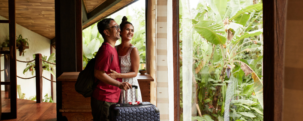 Couple smiling looking out at tropical landscape