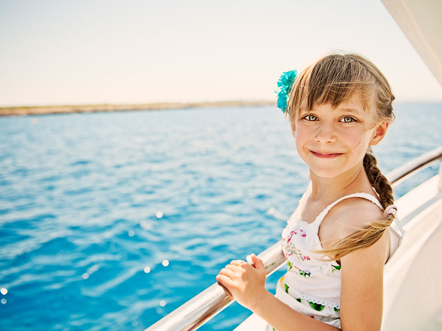 A girl standing on a cruise deck overlooking the sea