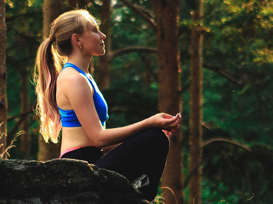 Woman practicing Yoga in the woods