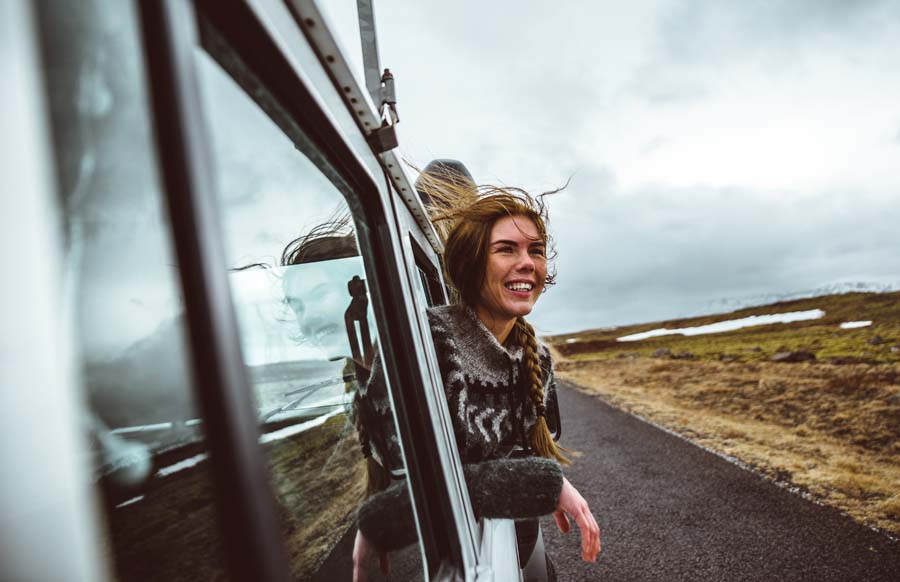 smiling woman looks out from a car in Iceland