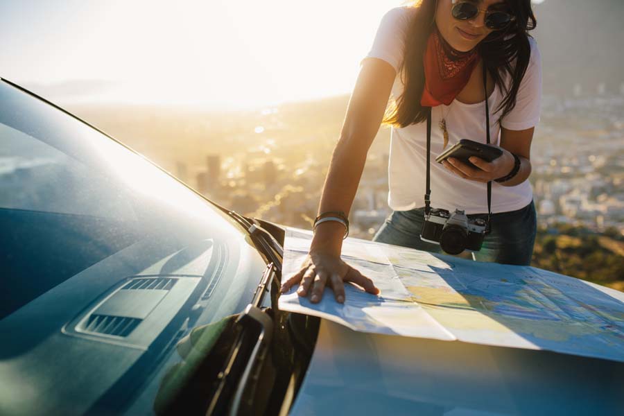 A woman looking at a map on the side of the road