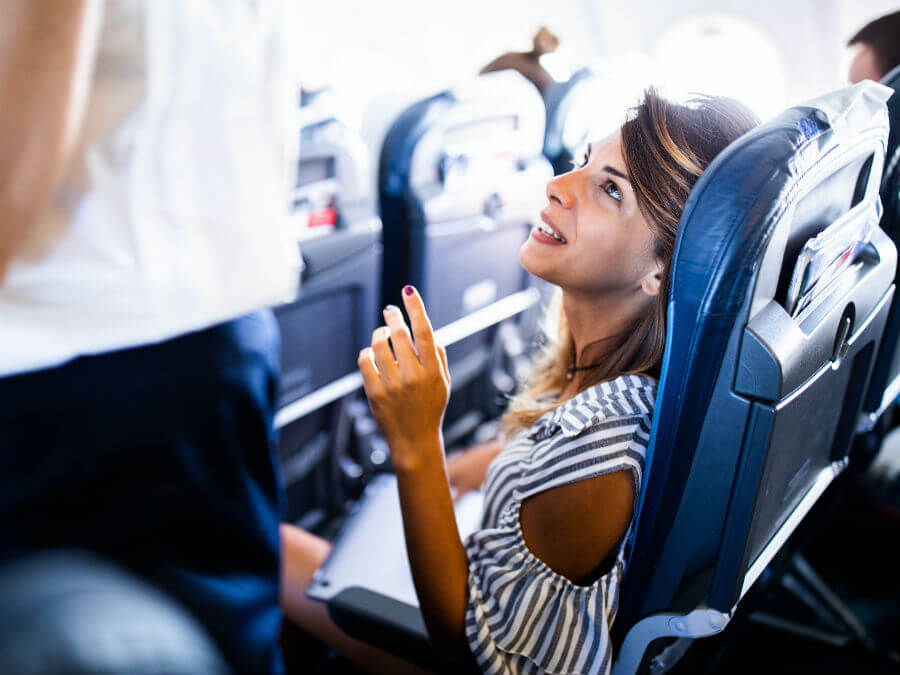 Girl passenger asking help from the air hostess
