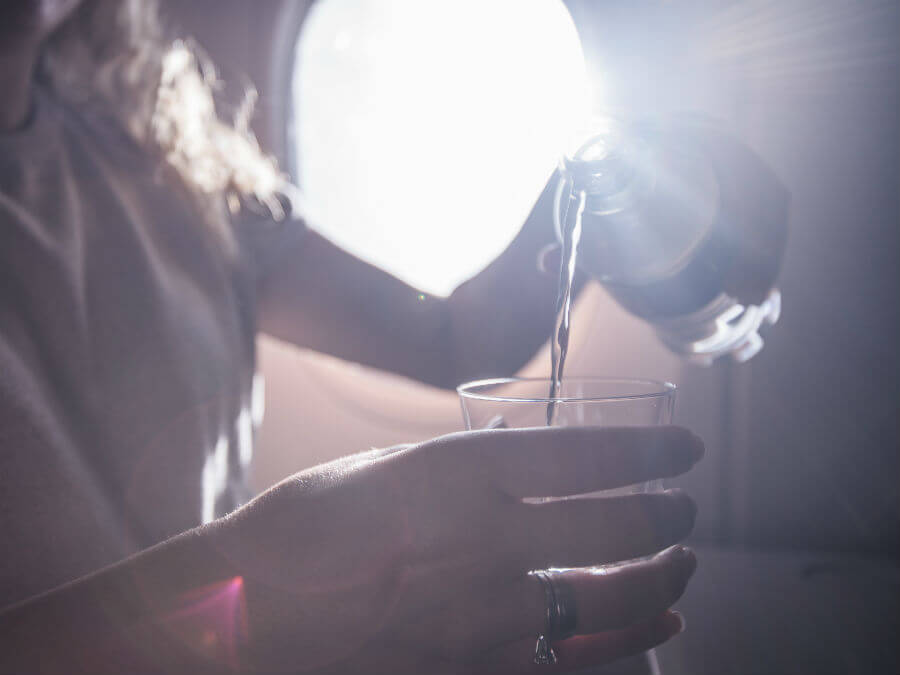A passenger drinking water while on a flight
