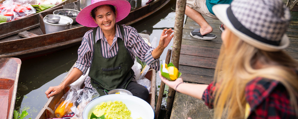 Smiling fruit selling on floating market boat