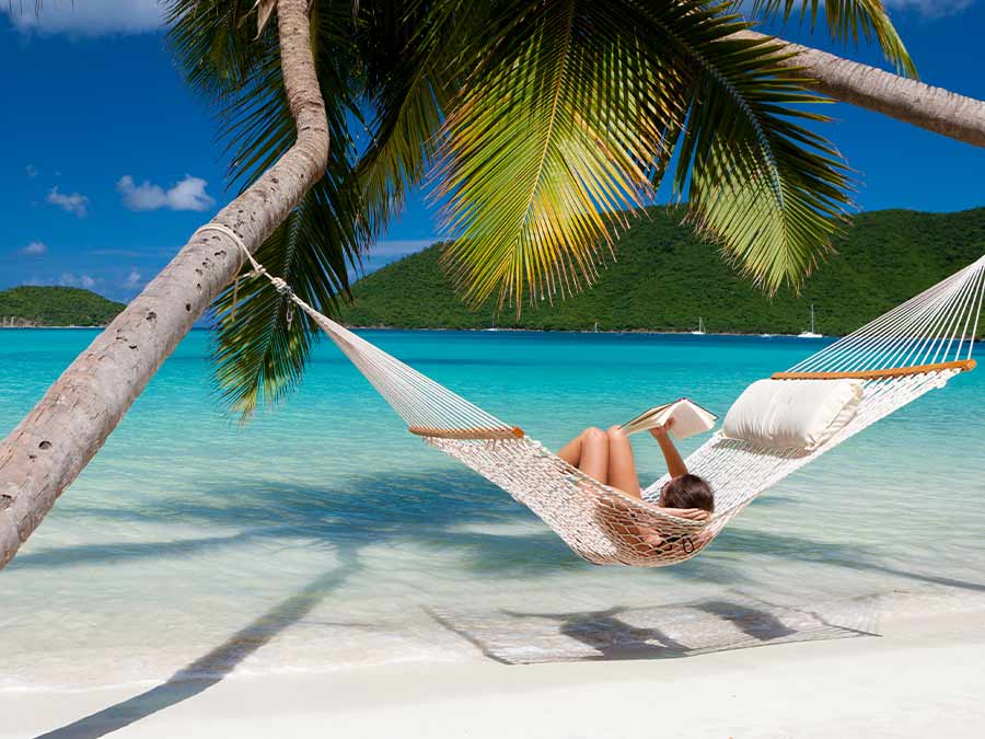 Woman relaxing on hammock on tropical beach 