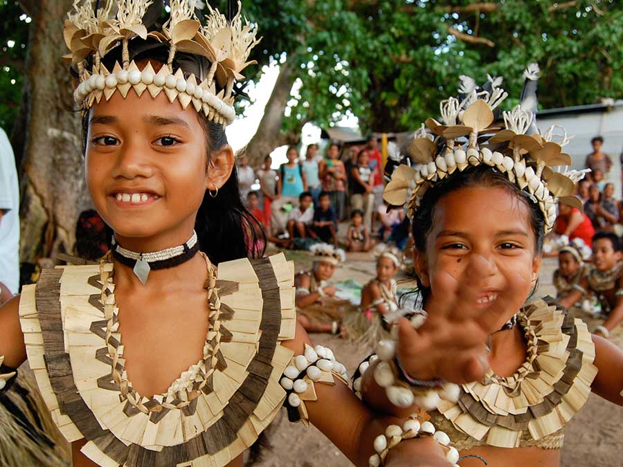 A couple of girls dancing in traditional Fijian clothing