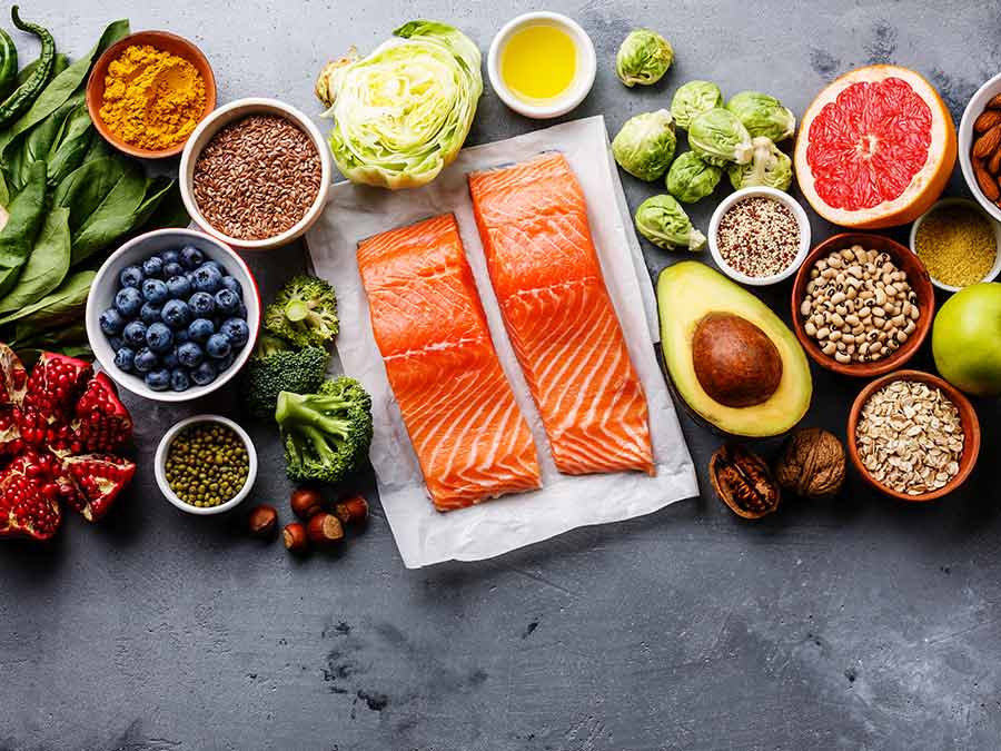 Fresh food including berries, salmon, avocado, nuts